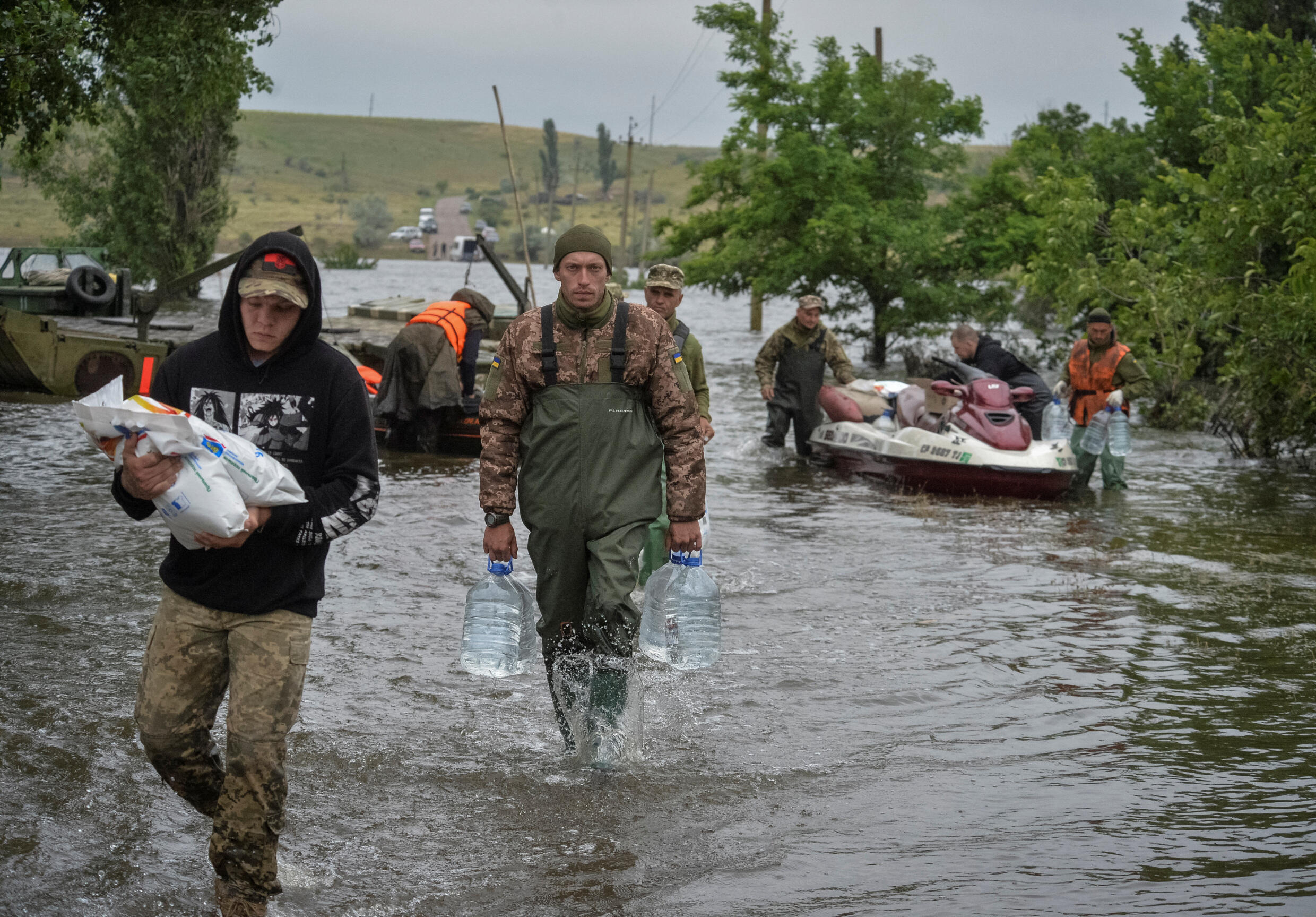 Des militaires ukrainiens déchargent de l'aide humanitaire pour les résidents locaux, après la rupture du barrage de Nova Kakhovka, dans le village inondé d'Afanasiivka, dans la région de Kherson, en Ukraine, le 12 juin 2023.